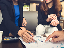 envisionglobal-blog_succession_planning_assessment_financial_adviser_working_with_clients_analyzing_data_at_the_ta_0